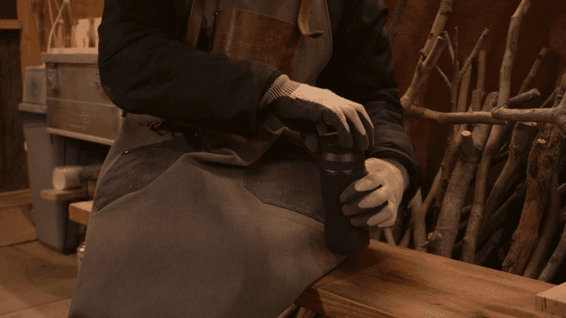 목공소에서 텀블러 뚜껑을 여는 공예가