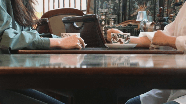 Two people having a conversation over coffee