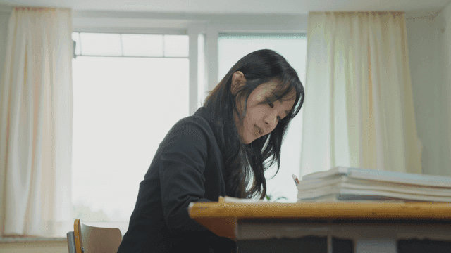 밝은 교실에서 책상에 앉아 공부하는 학생