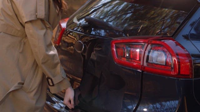 Person Removing Travel Luggage from Car Trunk