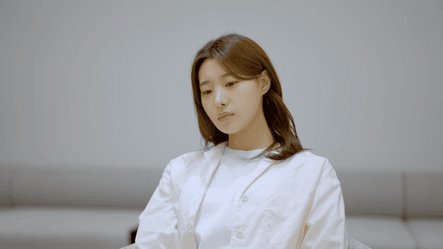 실내에서 시간을 확인하며 순서를 기다리는 여성