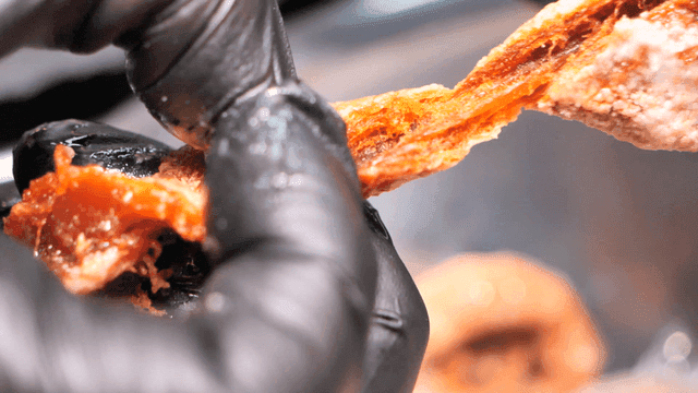 Dried persimmons torn by gloved hands