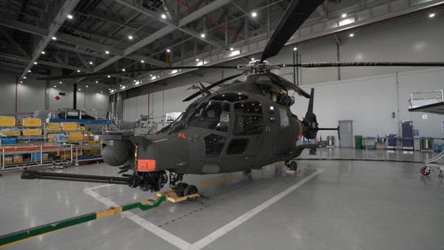 Helicopter displayed inside an industrial hangar