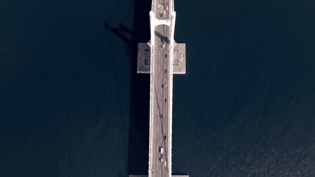 고층 건물이 있는 해안 도시 위의 다리