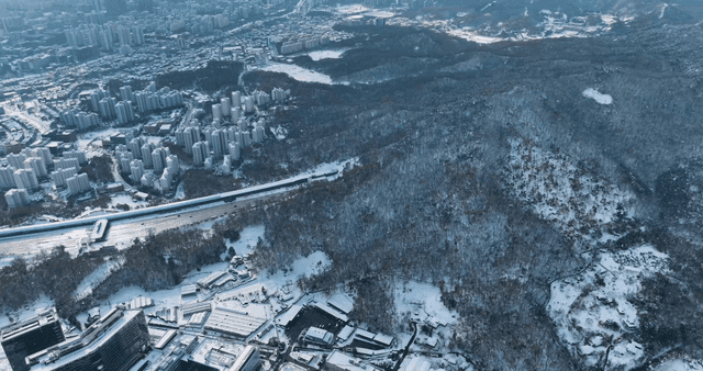 Winter cityscape below snowy mountains
