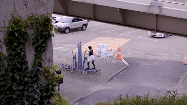 야외에 있는 운동기구에서 운동을 하는 여성