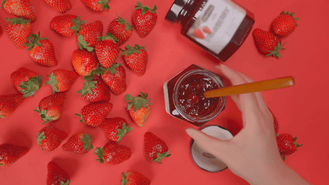 빨간 배경 위의 딸기와 잼