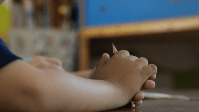 교실에서 연필을 쥔 아이