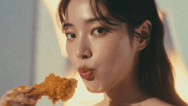 프라이드 치킨 닭다리를 뜯어먹는 젊은 여성