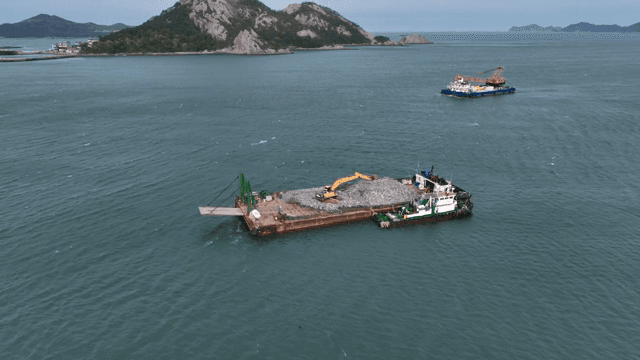 섬 근처 바다를 항해하는 화물선