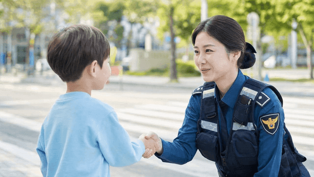 Police officer shaking hands with child