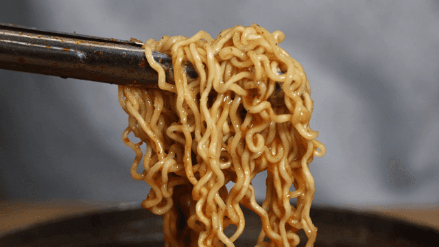 Cooked gamjatang ramen noodles picked up with tongs