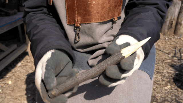 야외에서 날카로운 나무 막대를 점검하는 목공예가