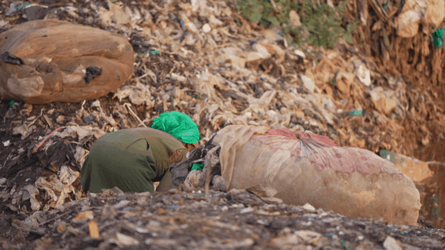 Person rummaging through pile of trash