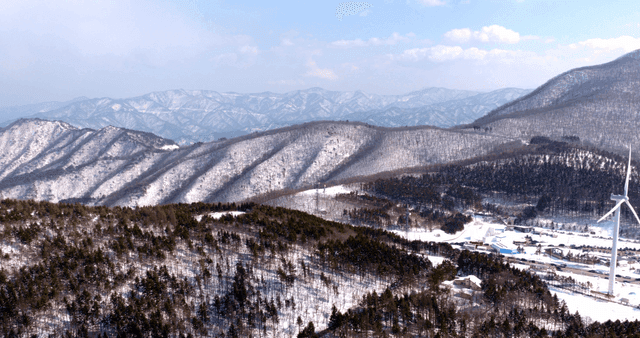 Snow-covered mountains with wind turbines