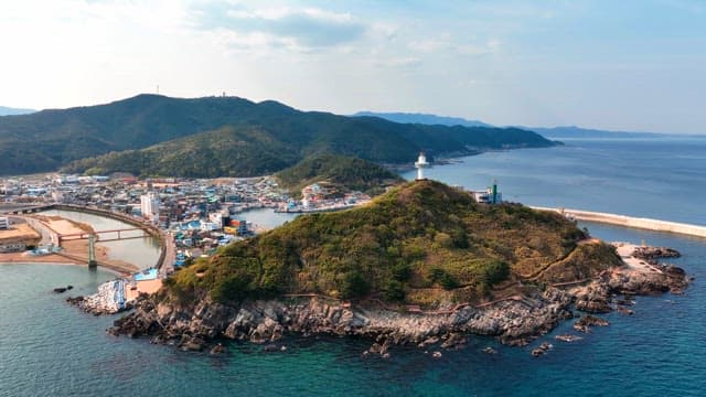 Coastal town with a lighthouse on a hill