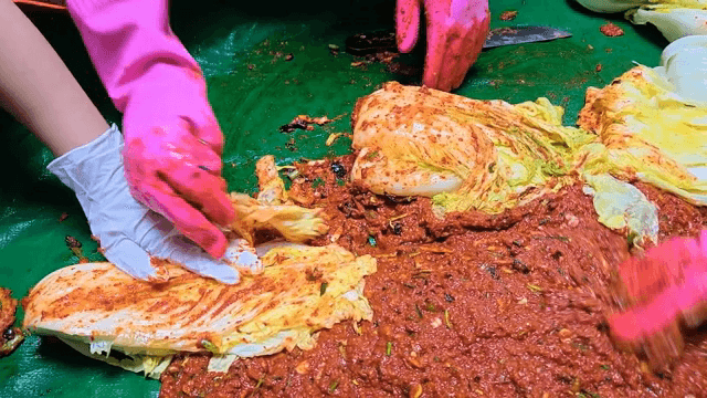 Kimchi being prepared with spices