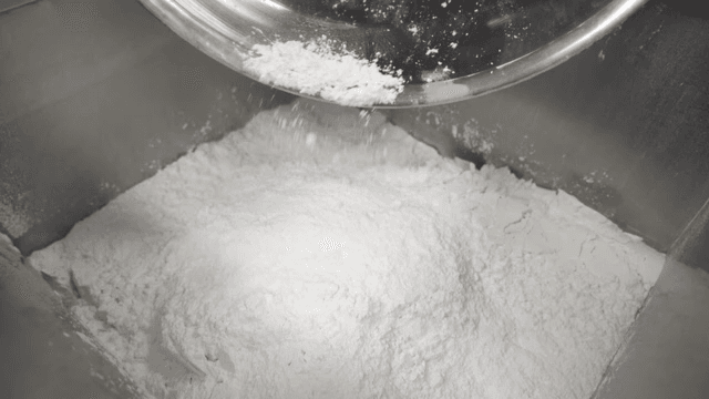 Flour being poured into a mixing bowl