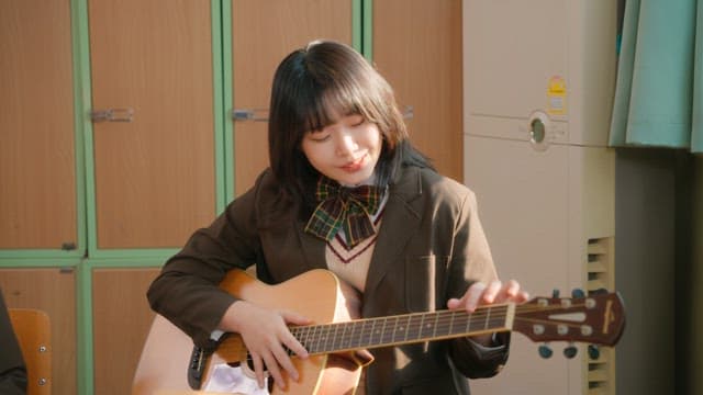 Student playing guitar in a classroom