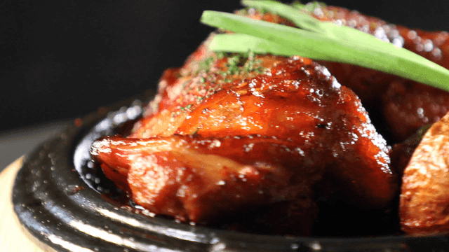 Wood-fired grilled chicken legs topped with vegetables