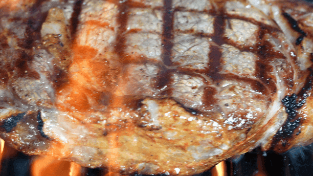 Grilled steak with flames on a barbecue