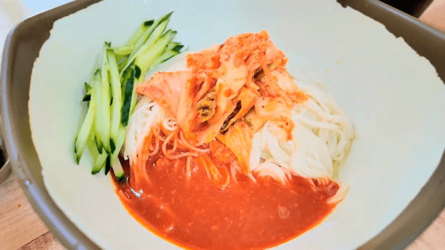 오이와 김치가 올려진 비빔국수