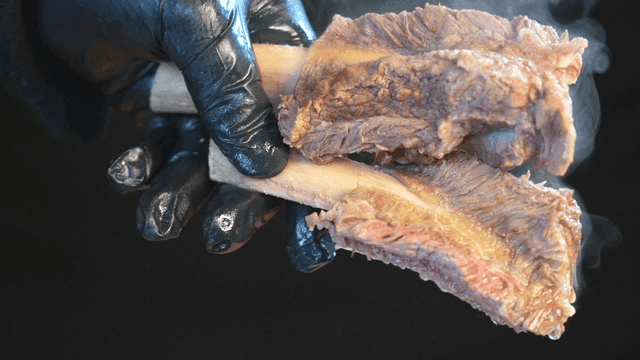 Hand lifting tender meat in galbitang