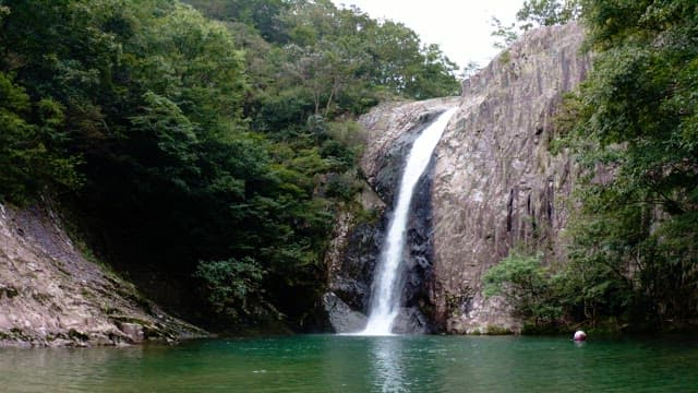 Majestic waterfall cascading between lush green cliffs