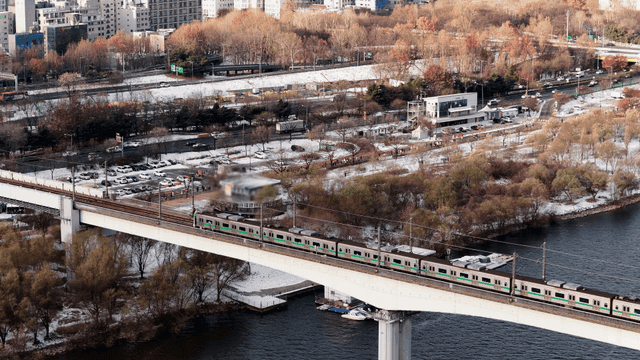 Train crossing a bridge over a river in winter