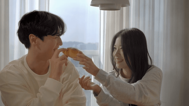 Couple smiling by window while smelling salt bread