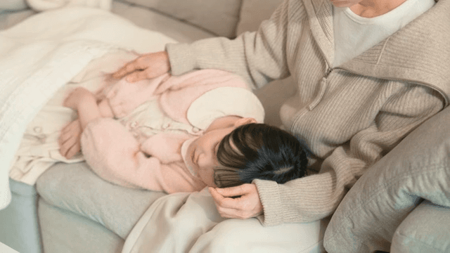 Mother gently watching her sleeping child