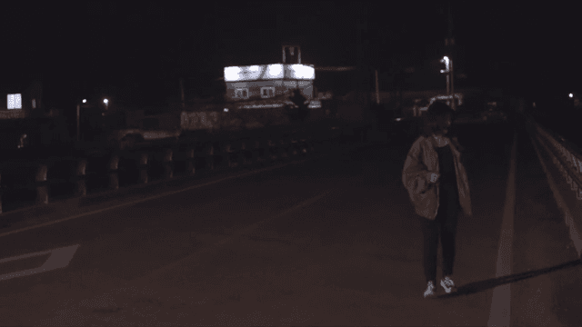 울음을 참으며 밤 거리를 수색하는 여성