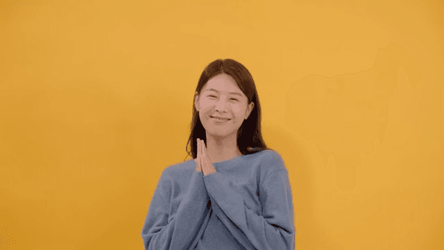 Long haired woman smiling and happy in gray sweater