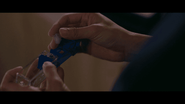 Hand holding blue earplug container