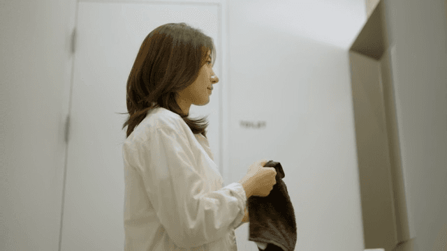 화장실에서 수건으로 손을 닦는 여성