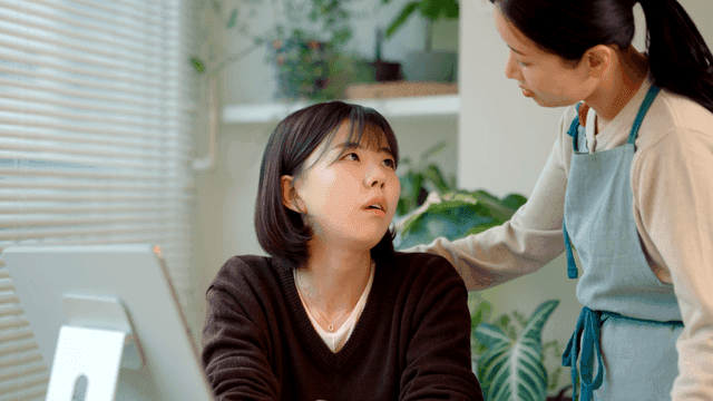 Mother comforts her daughter who is disappointed by her smartphone.