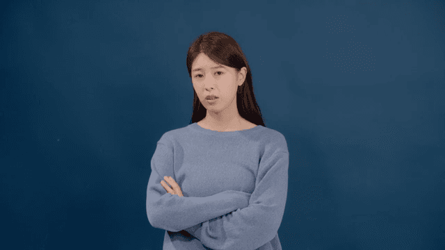 불만스러운 얼굴로 팔짱을 긴 머리의 여성