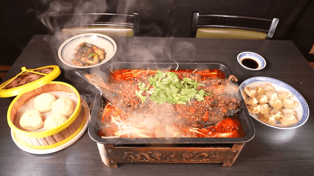Table with spicy fish Mala Kaoyu and dumplings