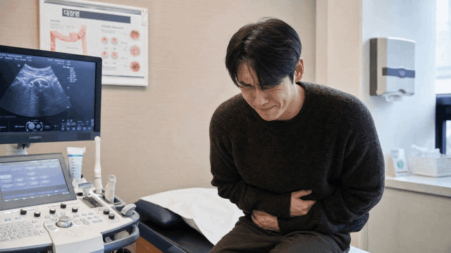 Man suffering from abdominal pain at clinic
