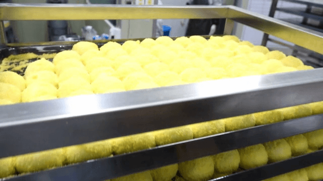 Yellow rice cake being prepared on a tray