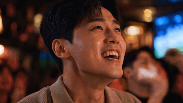 Excited man cheering in a lively bar