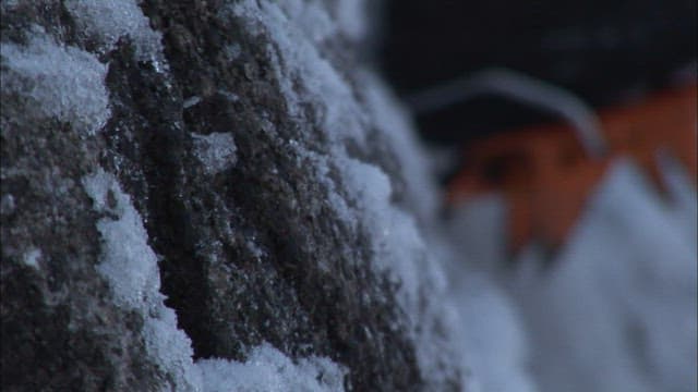 Climbing a snowy mountain face with ice axes