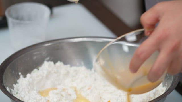 그릇에 밀가루와 계란 등 베이킹 재료를 섞는 장면