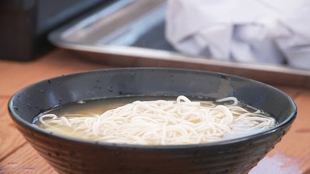 Mixing spicy condiment into a bowl of noodles