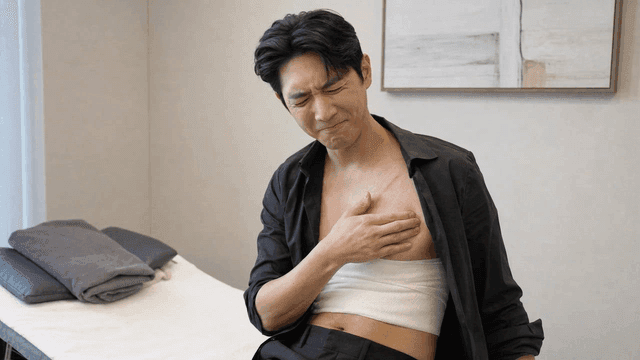 Male patient examining chest scar