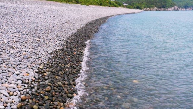 잔잔한 자갈 해변과 부드러운 파도