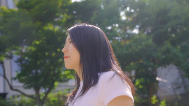 야외에서 웃으며 손을 흔드는 여성