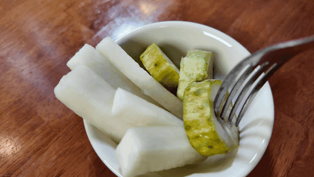 A small bowl of pickled radish and cucumber