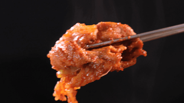 Spicy stir-fried pork picked up with chopsticks