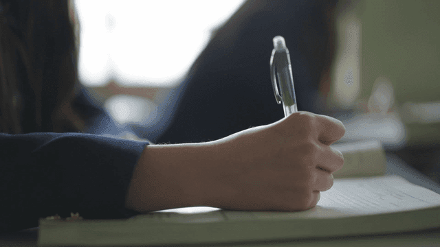 교실에서 노트 필기하는 학생